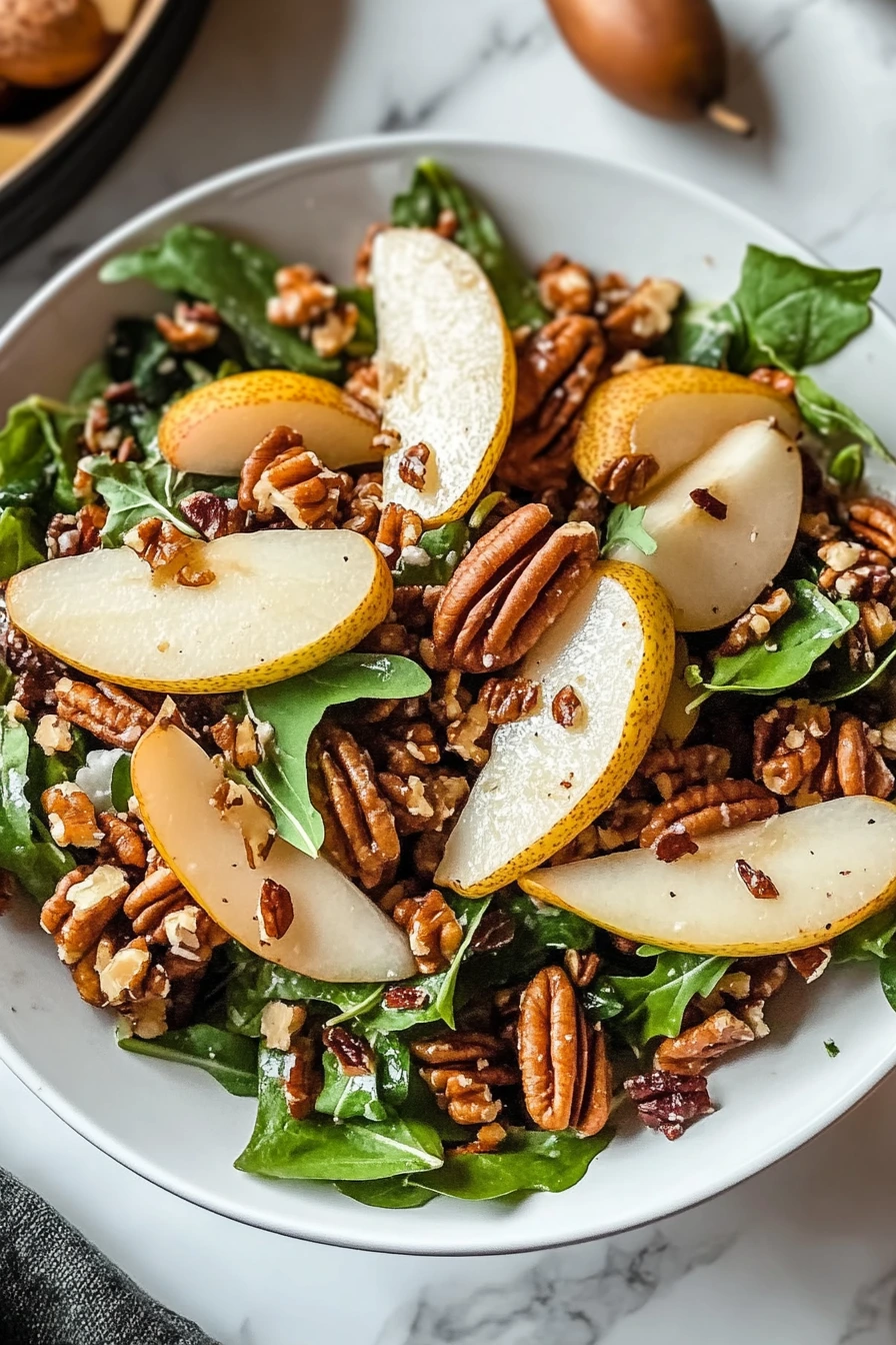 Rustic plate of harvest salad pears pecans served on wooden table.