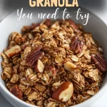 Golden-brown bowl of maple pecan granola with almonds and oats.