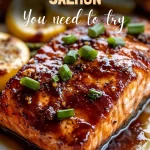 Perfectly baked maple glazed salmon fillet on a white plate.
