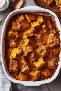 Serving of pumpkin bread pudding topped with whipped cream
