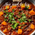 Bowl of hearty sweet potato chili with toppings and steam