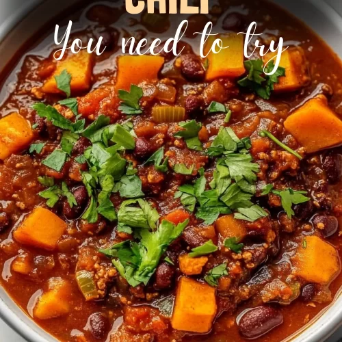 Bowl of hearty sweet potato chili with toppings and steam