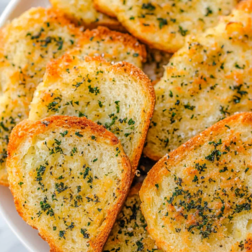 Close-up of crispy garlic bread with a cheesy, lightly browned surface.