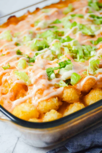 Cheesy tater tot casserole with seasoned ground beef and sliced pickles.