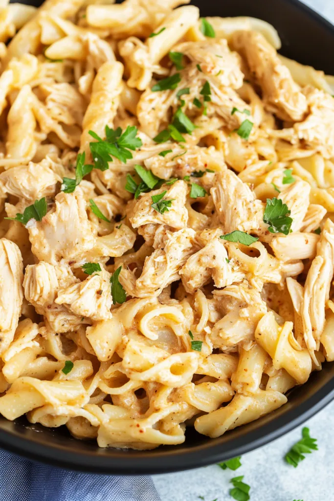 Creamy chicken pasta tossed with Parmesan garlic sauce and topped with fresh herbs.