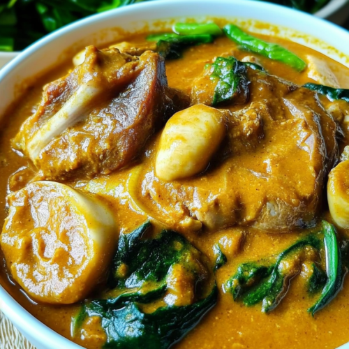 Rich peanut-based sauce covering tender oxtail pieces.