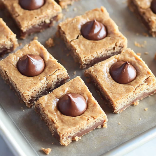 Close-up of soft dessert bars with chocolate pieces baked into the top.
