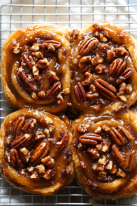 Freshly baked buns arranged on a white plate, showing their gooey texture.
