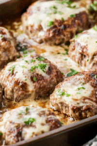 Close-up of baked beef patties smothered in smooth, flavorful gravy.