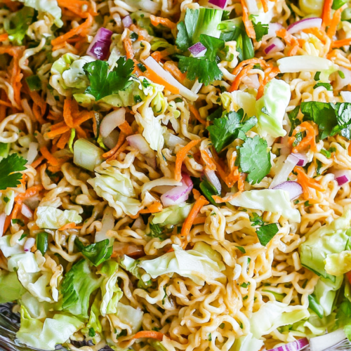 Close-up of shredded cabbage and carrots mixed with golden fried noodles.