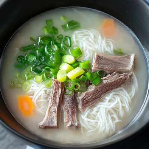 Close-up of tender beef slices and glass noodles in a traditional Korean seolleongtang recipe.