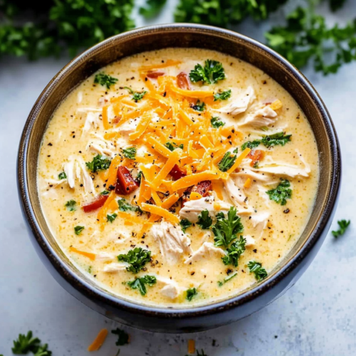 Slow cooker crack chicken potato soup served hot, rich with cheese and tender chicken pieces.