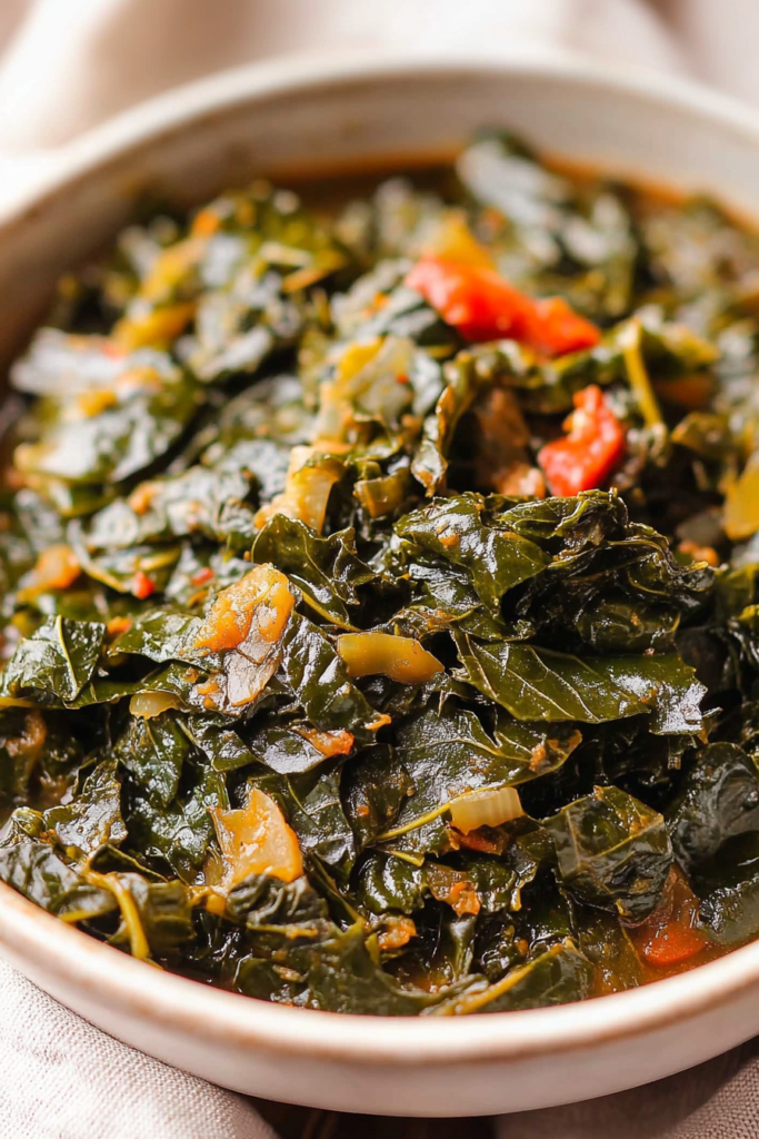 Close-up of glossy greens in a white bowl, garnished with fresh tomato and onion.