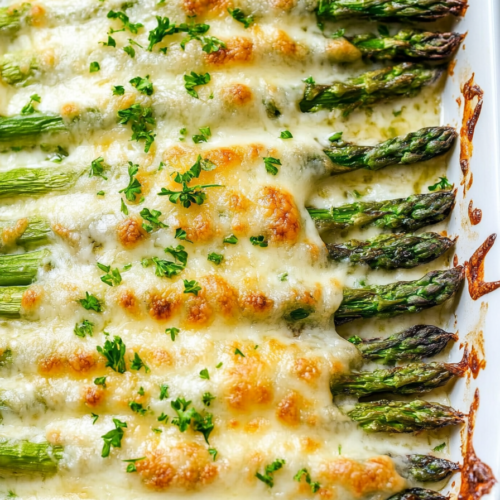 Close-up of asparagus baked until tender, topped with bubbly browned cheese.