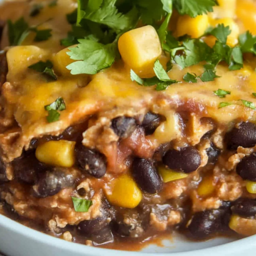 Close-up of a cheesy bean and corn bake with a rich tomato sauce