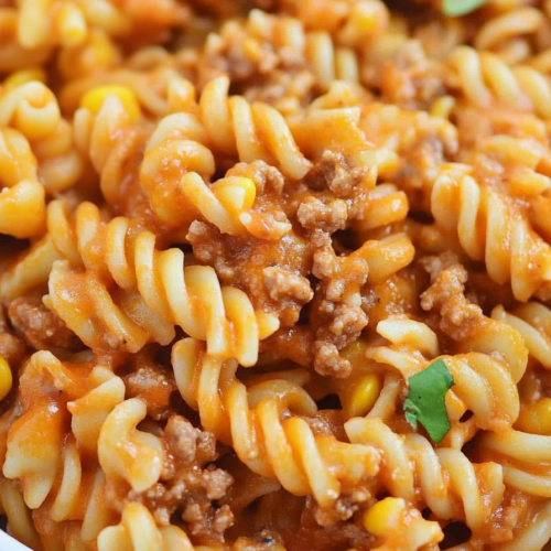 Close-up of cheesy beef pasta coated in a rich, savory sauce