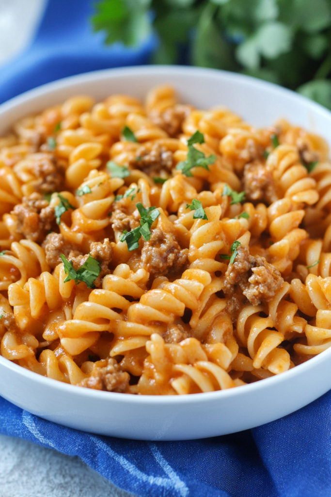 Hearty pasta dish with spiral noodles, ground meat, and creamy sauce