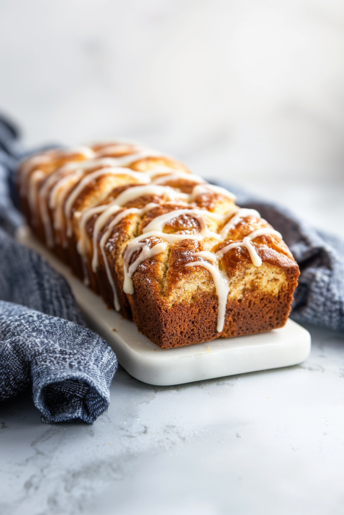 Soft golden loaf cut into sections with a light sugar glaze on top.