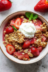 Rustic baked fruit dessert topped with crunchy oats and mint garnish