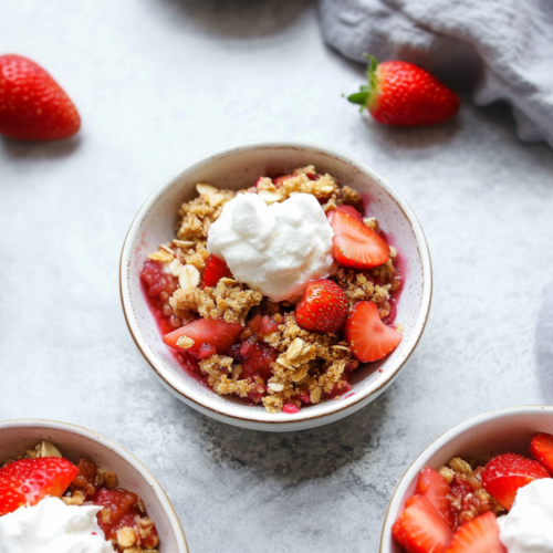 Homemade fruit crisp with fresh strawberries and crumbly topping in a ceramic bowl