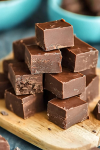Plated serving of fudge cubes with a pop of color from turquoise bowls in the background