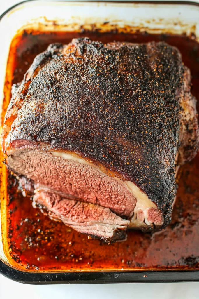 Juicy roast beef with a peppery crust and visible juices pooling beneath.