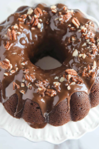 Easy Texas Sheet Cake Bundt topped with nuts and drizzled with chocolate glaze