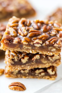 Close-up of sliced pecan dessert bars showing layers of crust and nut filling