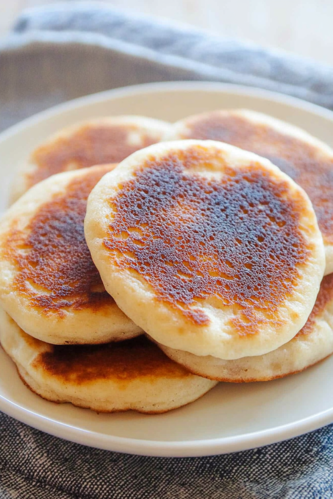 Round, golden pancakes arranged neatly, their glossy tops hinting at a sweet filling inside.