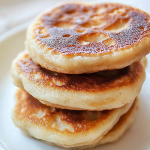 Stack of warm, pan-fried bread with browned spots, highlighting their rustic homemade look.
