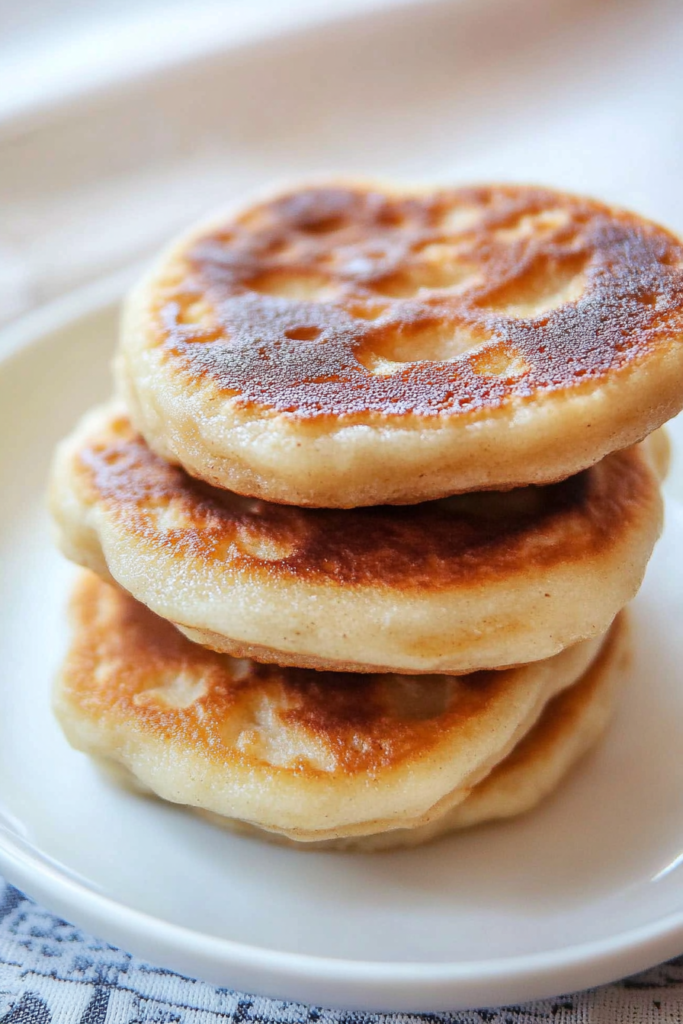 Stack of warm, pan-fried bread with browned spots, highlighting their rustic homemade look.