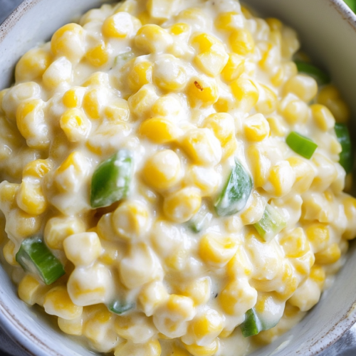 Bright yellow corn with green pepper pieces in a creamy base