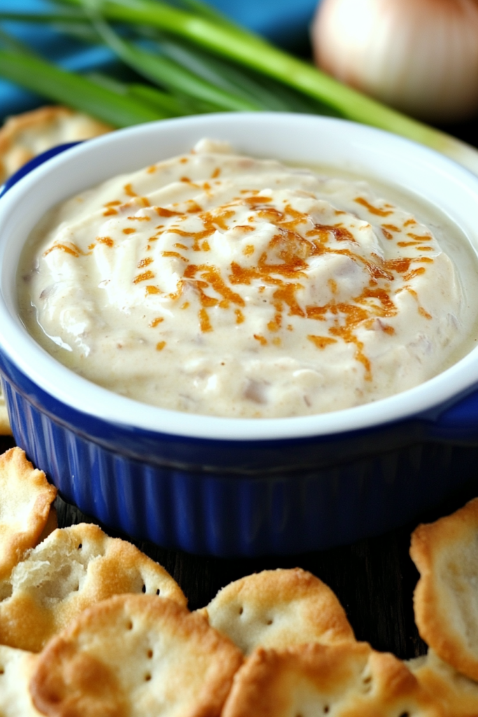 Thick, flavorful dip with a glossy finish, presented alongside crackers on a rustic surface.
