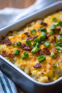 Family-style potato casserole garnished with bacon crumbles and green onion for a hearty comfort dish.