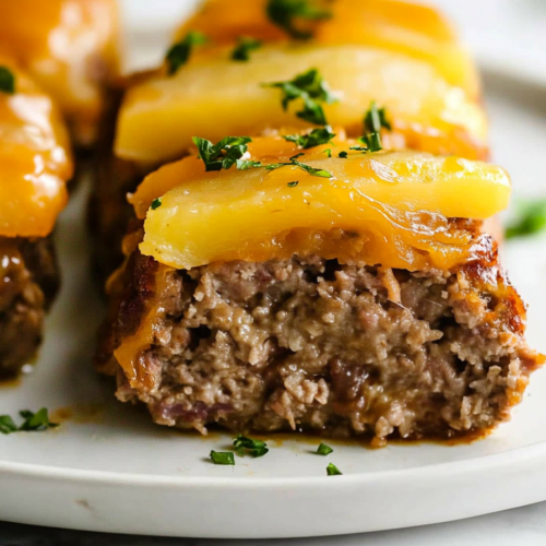 Savory meatloaf stack with potatoes and melted cheese, ready to serve.