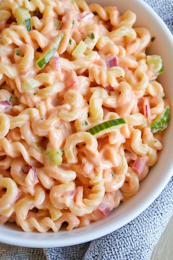 Finished pasta salad with a rich, creamy texture and colorful veggie pieces.