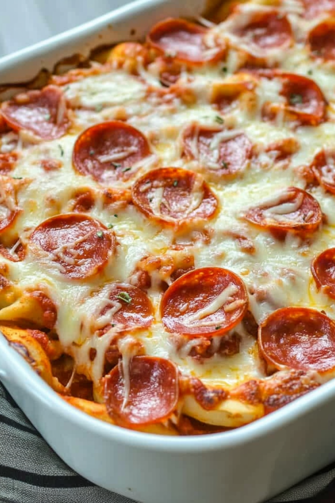Family-style baked pasta dish with pepperoni scattered across a bubbling cheese topping.