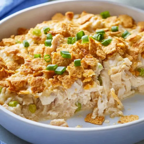 Close-up of a golden cracker crust over tender shredded chicken in a casserole pan.