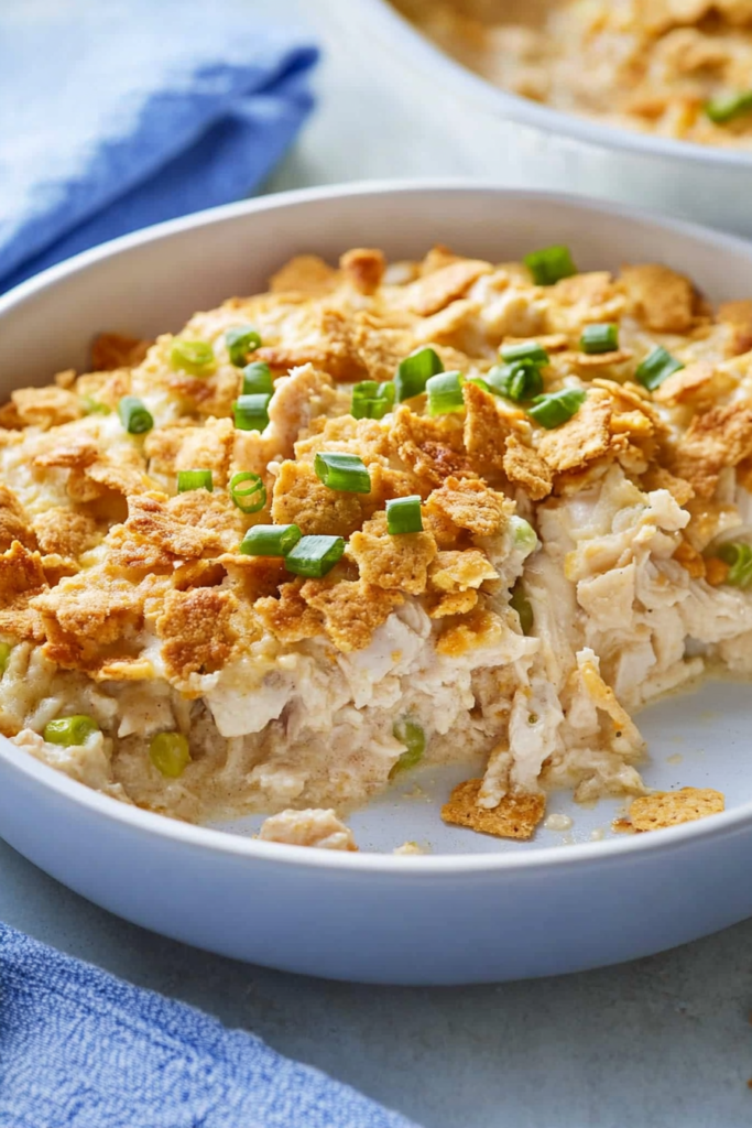 Close-up of a golden cracker crust over tender shredded chicken in a casserole pan.