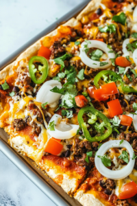 Overhead view of a golden pizza loaded with savory meat, cheese, and fresh sliced vegetables.