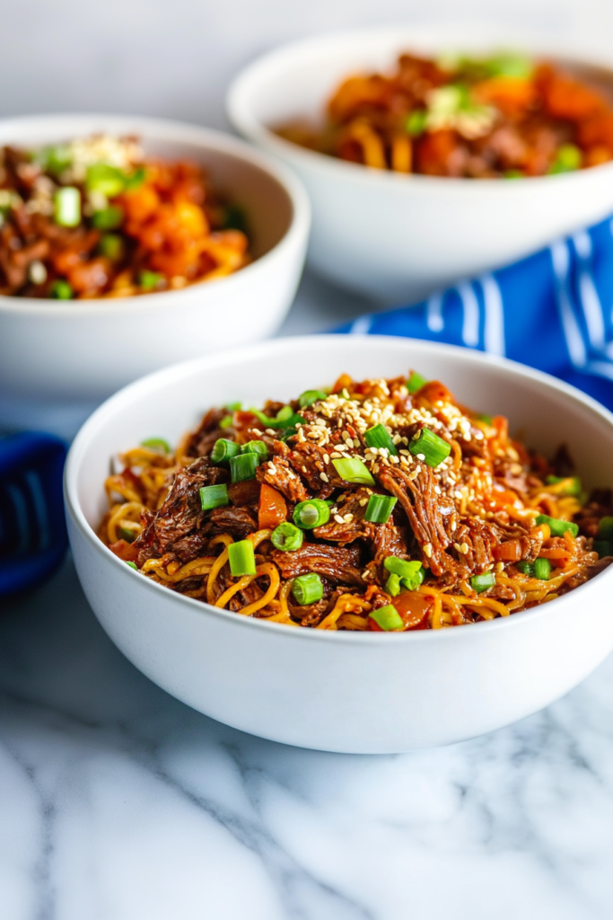 Final plated shot of Slow Cooker Korean Beef Noodles, styled with chopsticks and vibrant garnish.