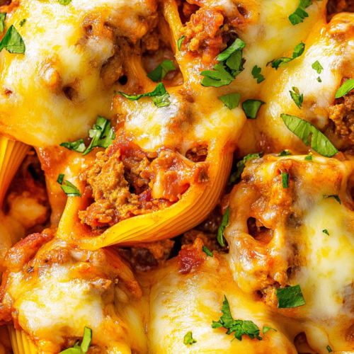 Close-up of golden, cheesy stuffed shells arranged neatly in a baking dish.
