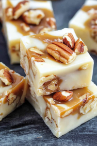 Close-up of smooth white fudge with chopped pecans inside and on top