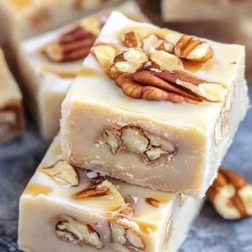 Stacked homemade fudge pieces with a rich, glossy finish and nutty texture