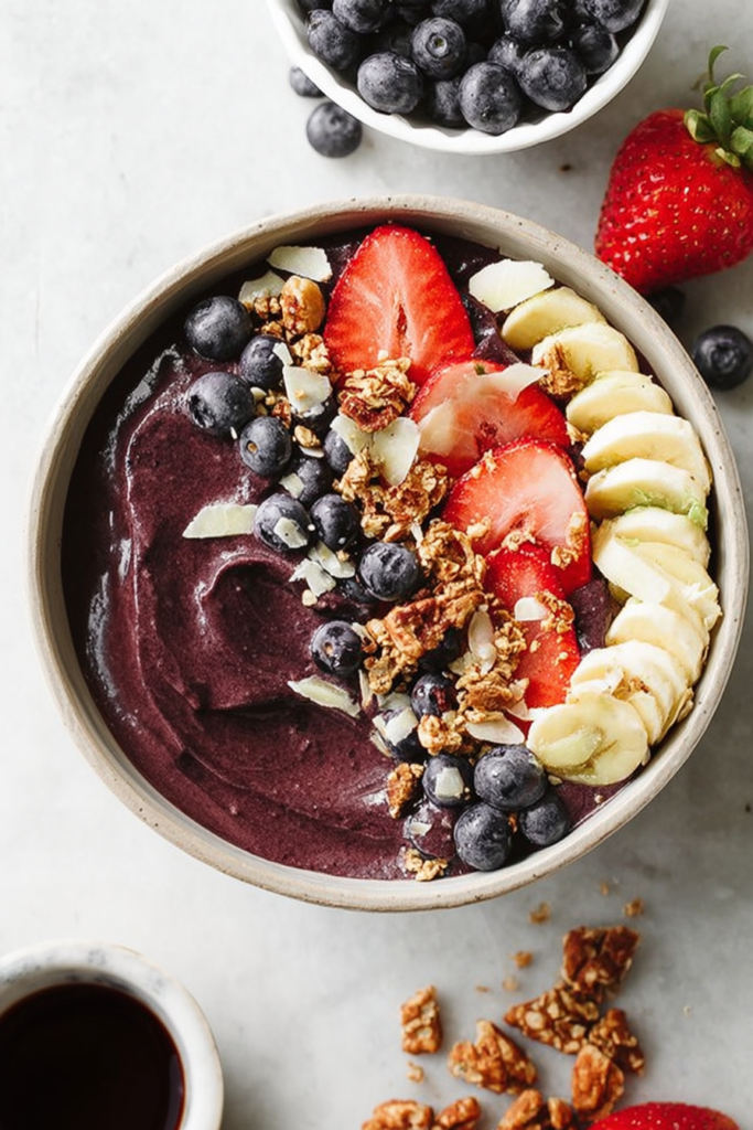 Breakfast bowl with mixed fruit, banana slices, and granola served in a ceramic bowl.