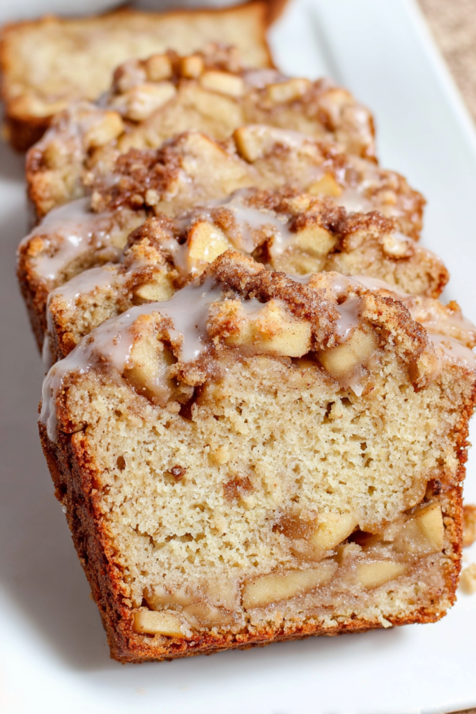 Close-up of cinnamon apple bread with a soft crumb and caramelized fruit layers.