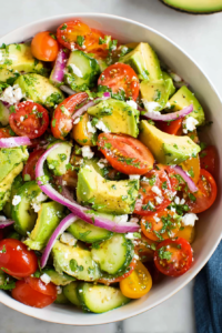Close-up of crisp cucumbers and creamy avocado mixed with juicy tomatoes