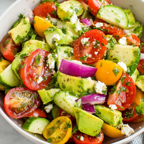 Fresh avocado, tomato and cucumber salad tossed with herbs and light dressing