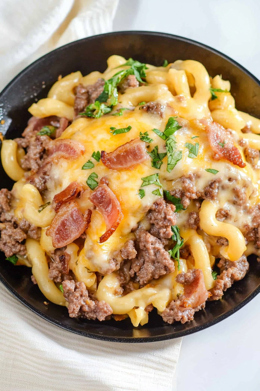 Comforting beef and cheese pasta topped with crispy bacon strips, served hot.