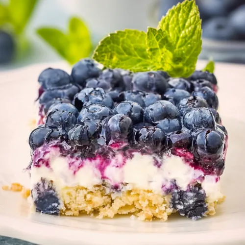 Final plated shot of a decadent berry dessert, highlighting the contrast of creamy white filling and deep purple topping.